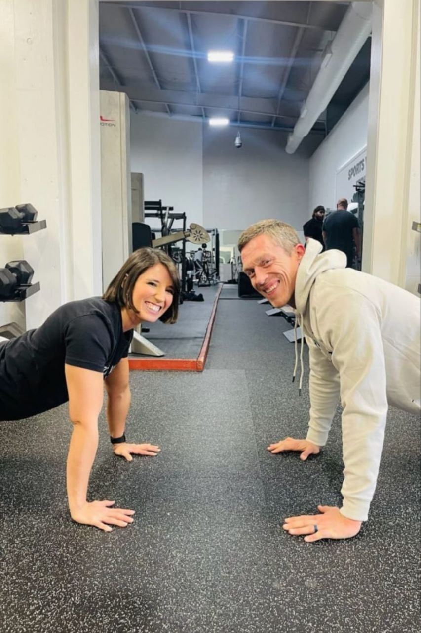 Andy and Holly holding a plank position in the gym
